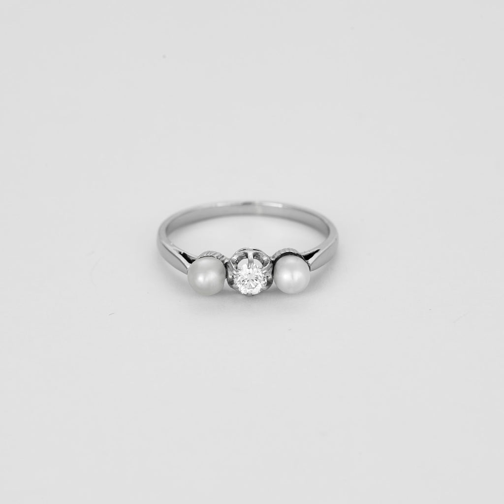Bague trilogie en or blanc sertie d'un diamant et de 2 perles.