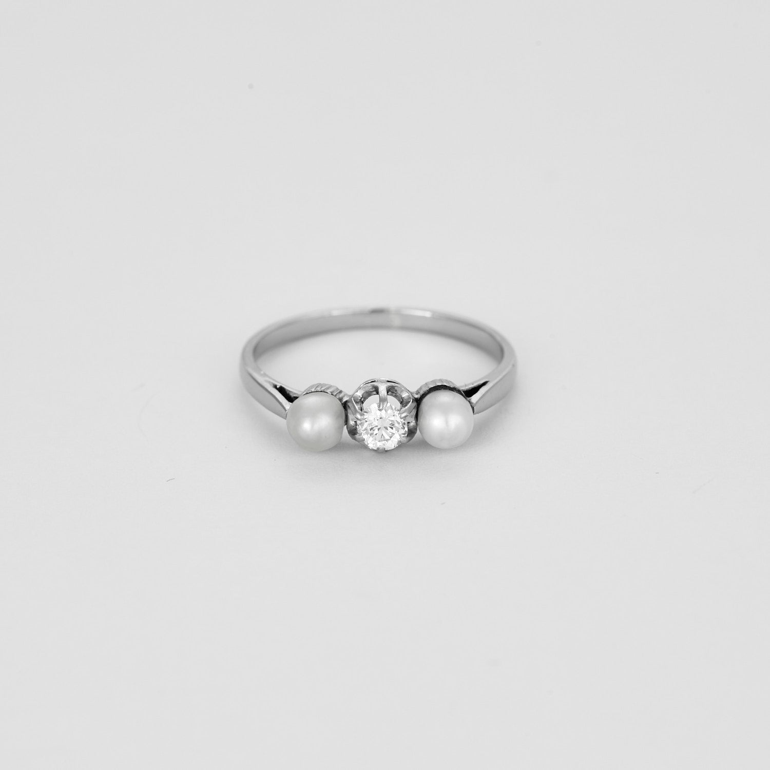 Bague trilogie en or blanc sertie d'un diamant et de 2 perles.