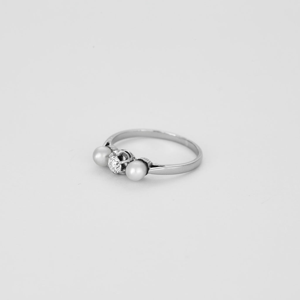 Bague trilogie en or blanc sertie d'un diamant et de 2 perles.