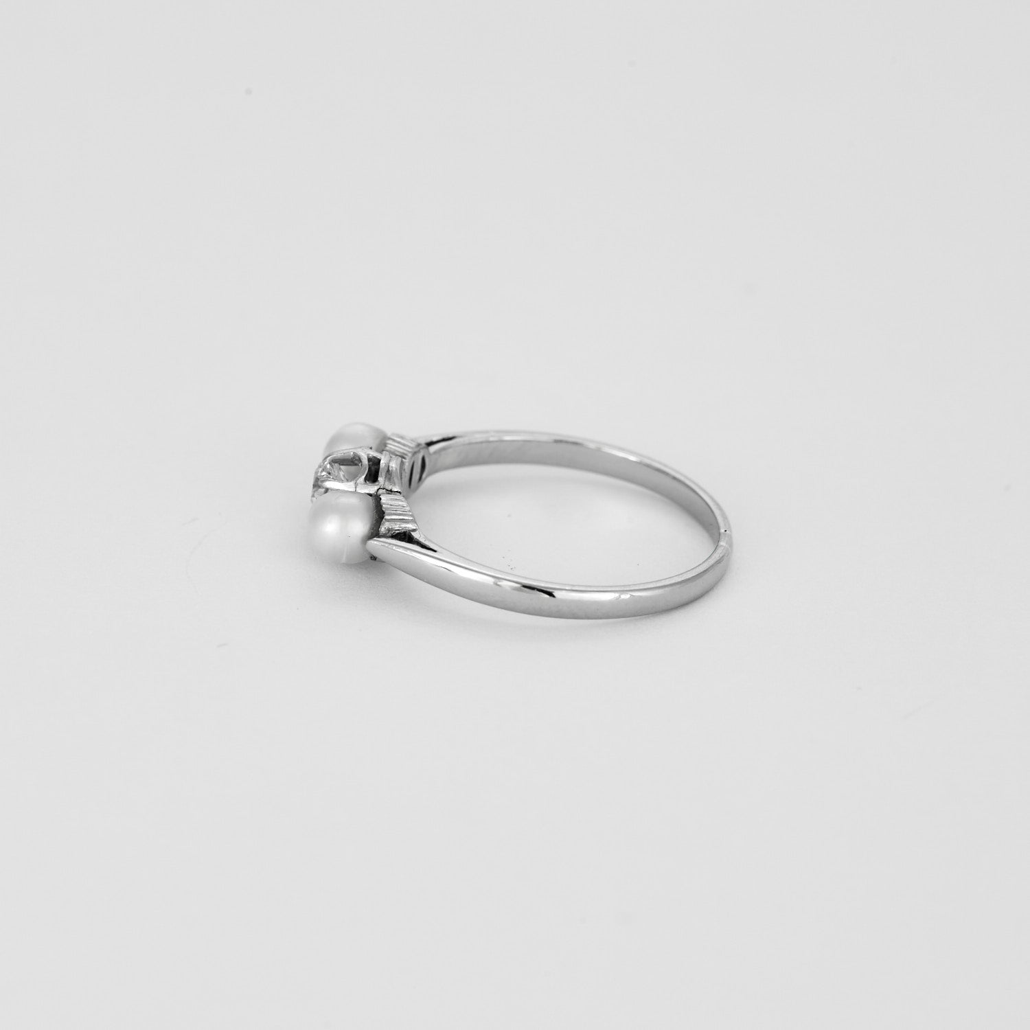 Bague trilogie en or blanc sertie d'un diamant et de 2 perles.