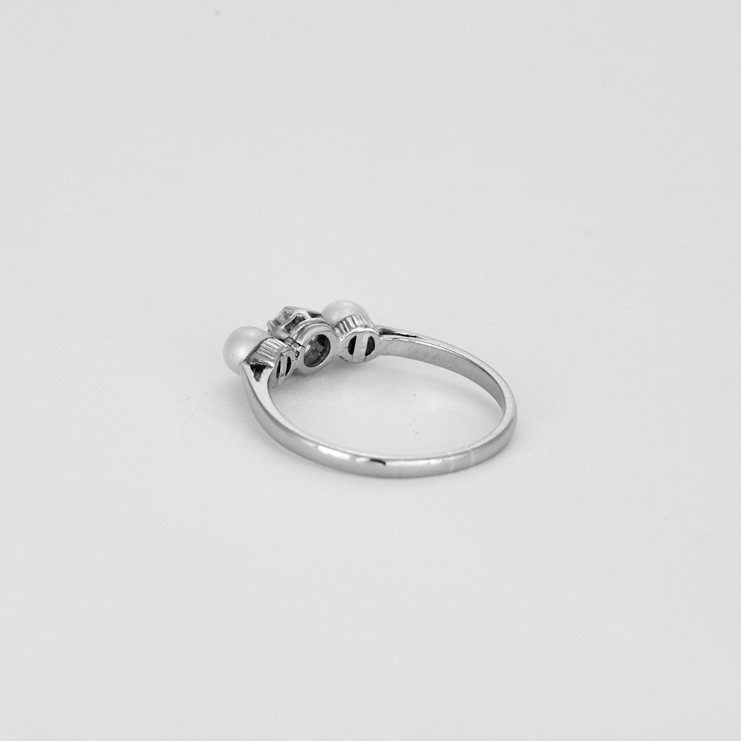 Bague trilogie en or blanc sertie d'un diamant et de 2 perles.