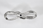 Broche Infini en platine, diamants et centre saphir.