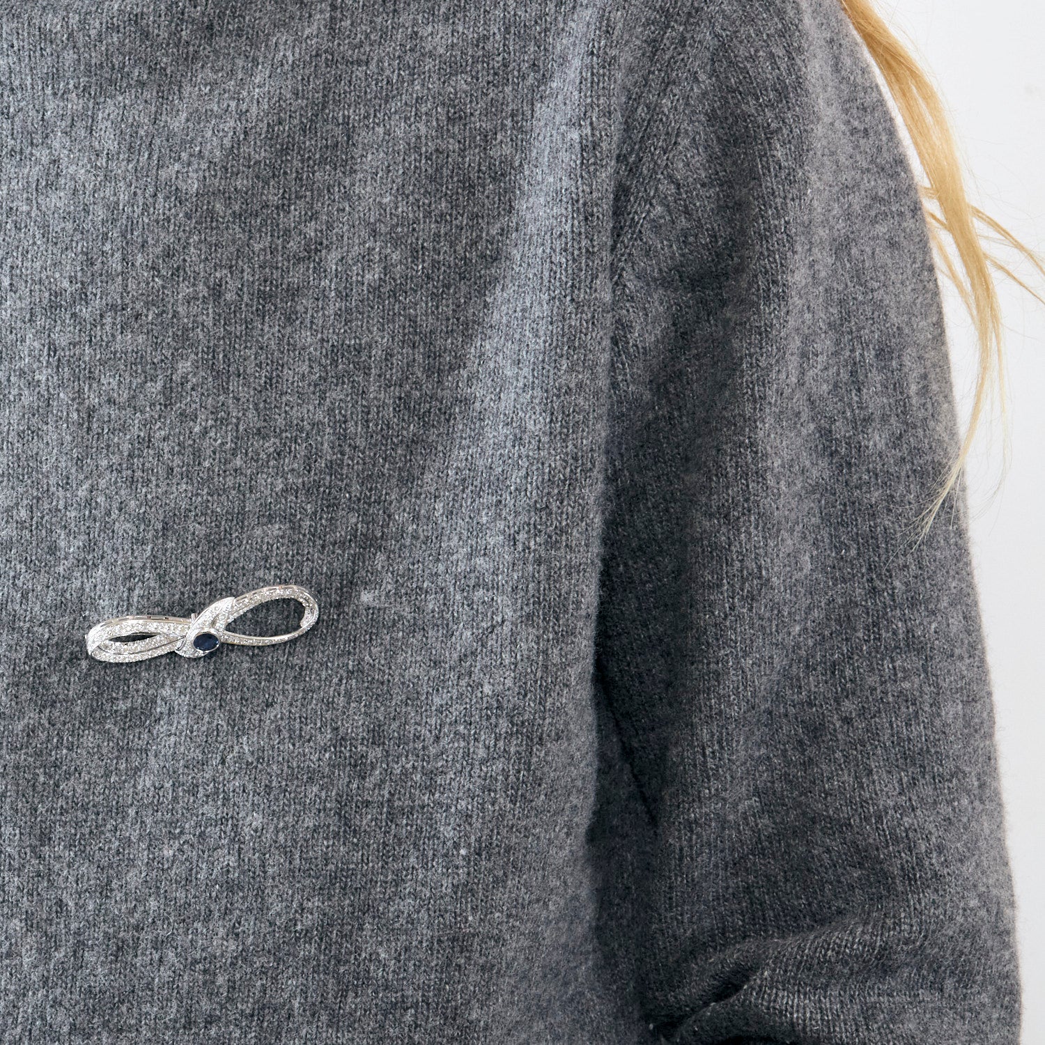 Broche Infini en platine, diamants et centre saphir.