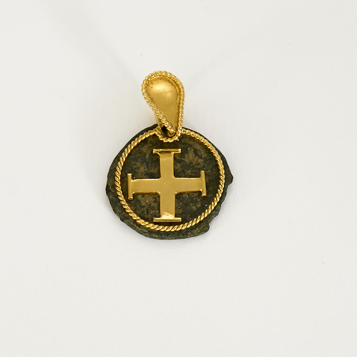 Médaille-croix ancienne en or jaune torsadé sur pierre.