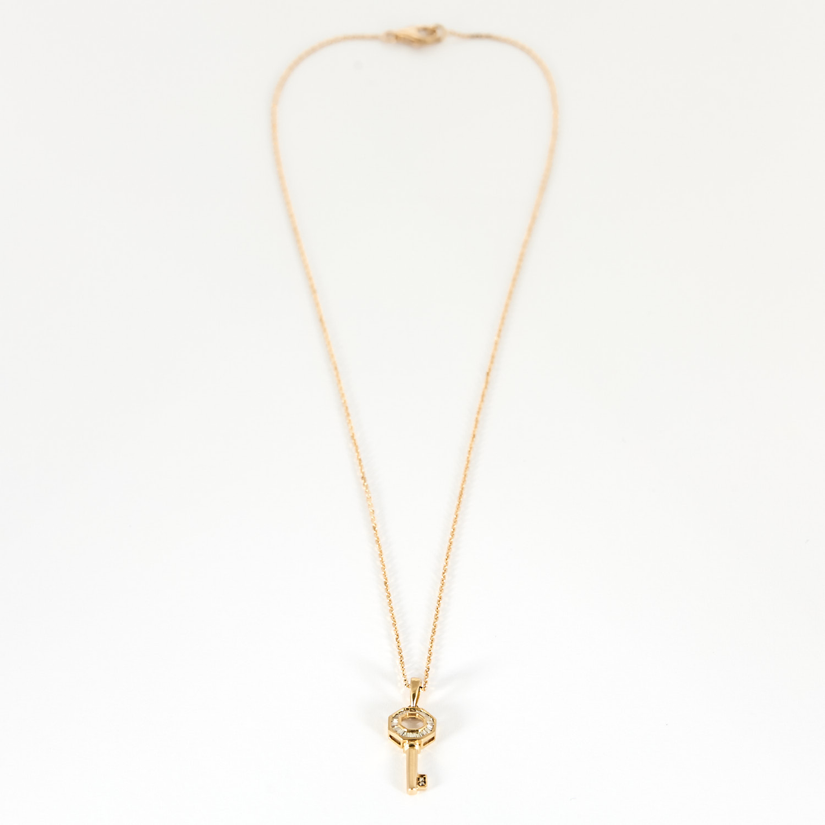 Collier Clé en or rose 18k et diamants baguettes.