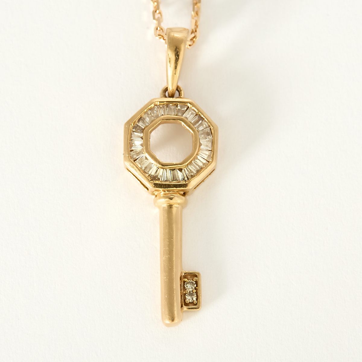 Collier Clé en or rose 18k et diamants baguettes.